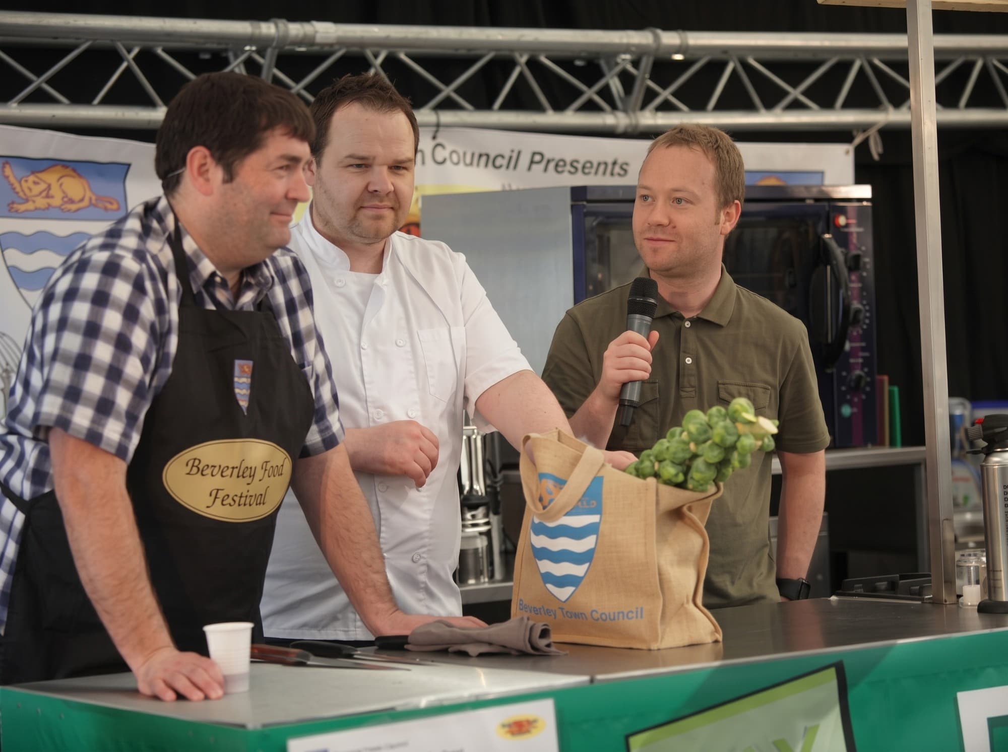 Jason on stage at Beverley Food Festival, considering a surprise bag of ingredients during a cooking challenge