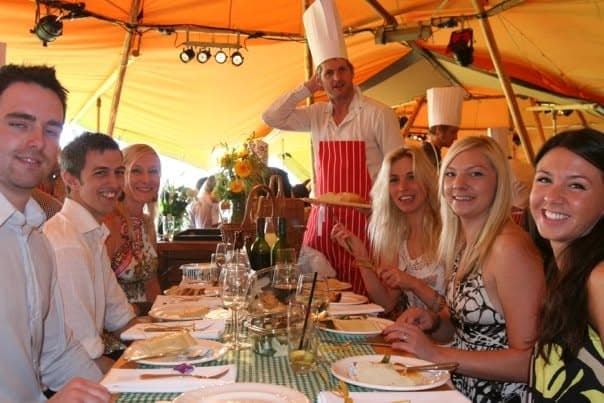 Jason carving at the table in a tipi marquee at the White Rose Polo Club, with guests seated around a picnic table